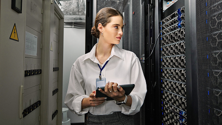 Žena s tabletom v serverovni predstavuje robustné pripojenie pre finančné a technologické centrá.