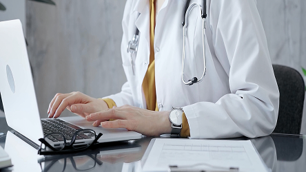 Lekárka pracujúca na notebooku – riešenia na ochranu zdravotníckych sietí a súlad s reguláciami v nemocniciach a klinikách.
